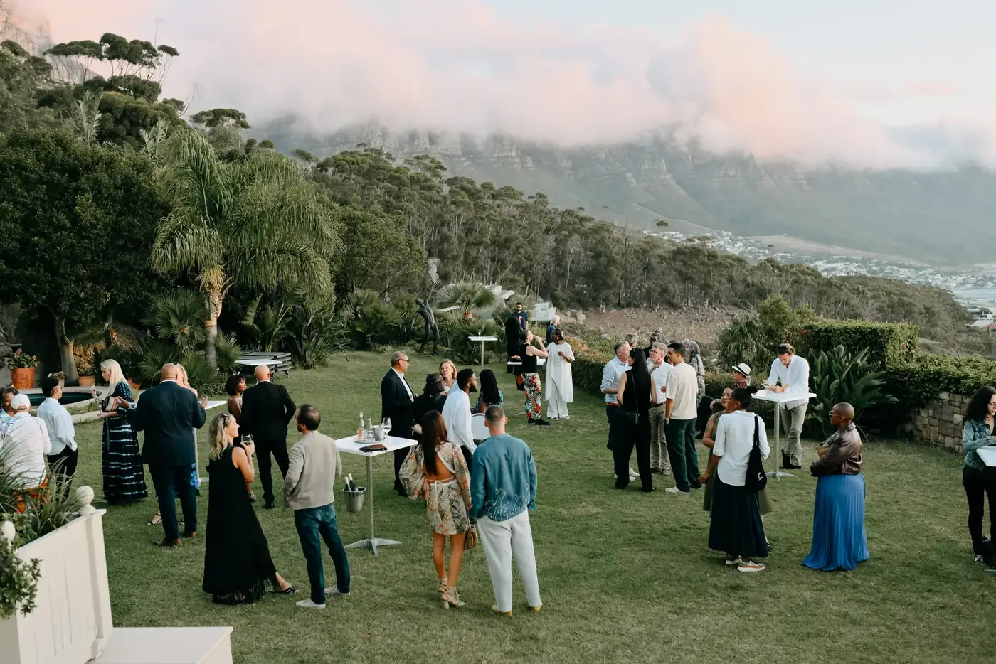 Guests mingling at an outdoor garden reception with Table Mountain in the background